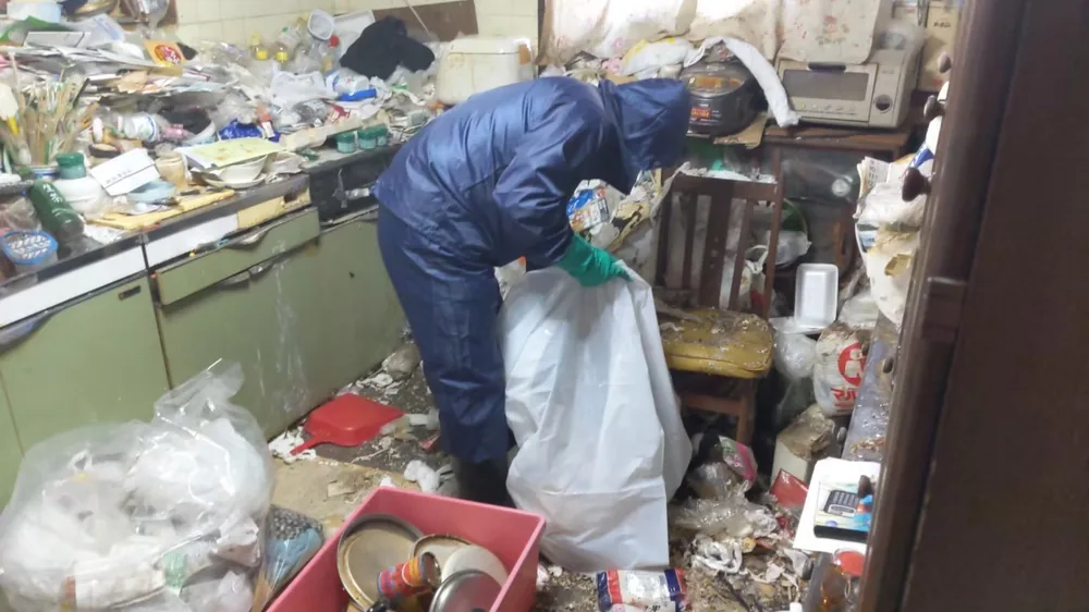 ゴミ屋敷清掃 作業中 防護服でのゴミ袋詰め